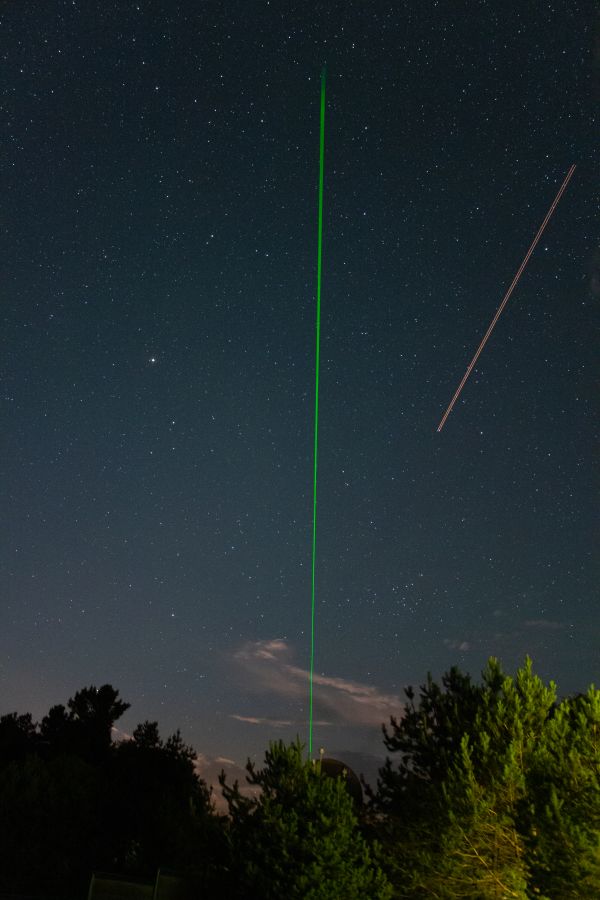 Laser rangefinder beam and passing aircraft - Astrophotography